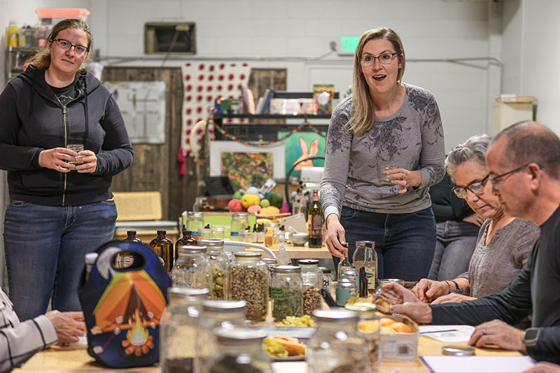 Attendees at a workshop for creating your own herbal bitters enjoy drinks and conversation at Atelier In Reno.