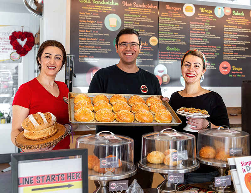 From left: L.A. Bakery Café & Eatery baker Sara Tavakoli, owner and manager Alireza Arbabha, and owner, baker, and pastry chef Leila Tavakoli present some of their breads and pastries. Photo by Olga Miller