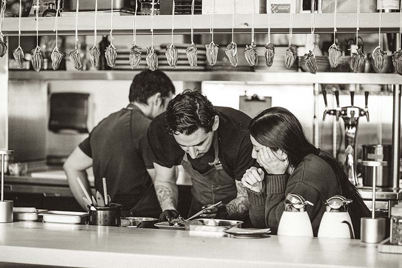 Chef Tyler Burges creates a culinary masterpiece at Smoke Door. Photo by Ingrid Nelson